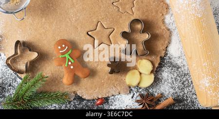 Fresh homemade dough for preparation christmas gingerbread cookies and baking cutters on scattered flour with decor. Kitchen holiday background  with Stock Photo