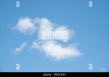 Bright blue sky filled with fluffy white clouds, varying in size and shape, creating a serene and tranquil scene. The clouds are well-defined against Stock Photo