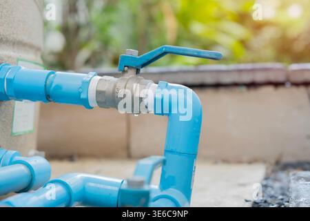 Blue PVC pipe with fauce setting in the garden are. Bule and iron faucet for watering the garden, water device. Stock Photo