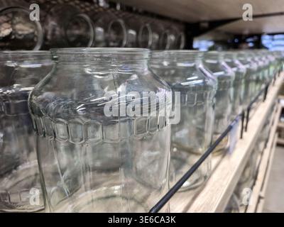Row of empty glass jars displayed on a store shelf for sale Stock Photo