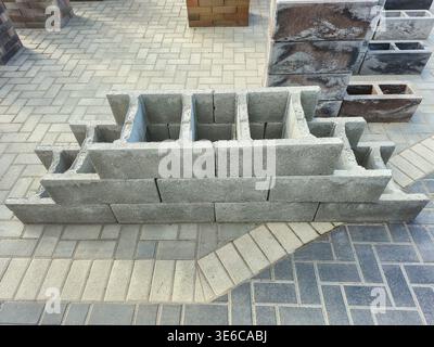 Stack of concrete blocks arranged in a tiered structure on a paved surface Stock Photo