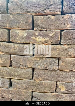 close up textured view of a stack of weathered, rustic brown bricks Stock Photo