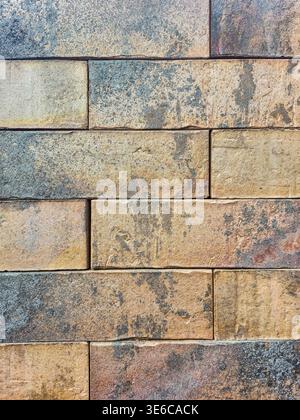 Weathered brick wall texture with earthy tones and subtle blue-grey accents Stock Photo