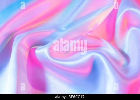 Shiny fabric creating flowing soft vibrant waves of pink and blue Stock Photo
