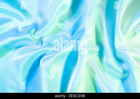 Draped blue and green silk satin fabric creating soft waves and folds Stock Photo