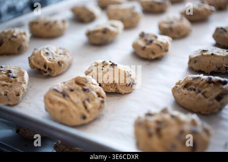 A view of raw cookie dough balls on a baking sheet. Stock Photo