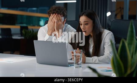 Two Caucasian colleagues losing with laptop upset failure partners business coworkers lost fail with computer feeling frustration businessman with Stock Photo
