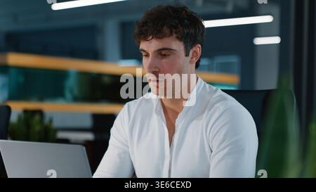 Serious Caucasian business man thinking working with laptop online work think job businessman guy male typing browsing computer internet technology Stock Photo