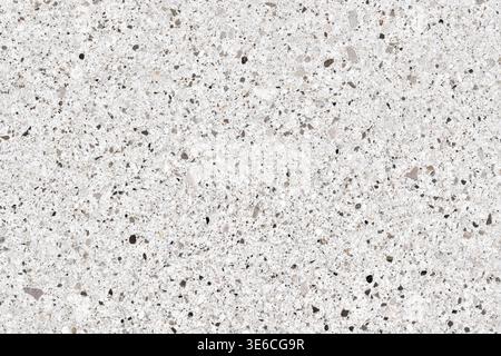 High-resolution view of a white terrazzo or quartz surface. Modern construction material featuring a mix of grey, black, and beige mineral stones Stock Photo