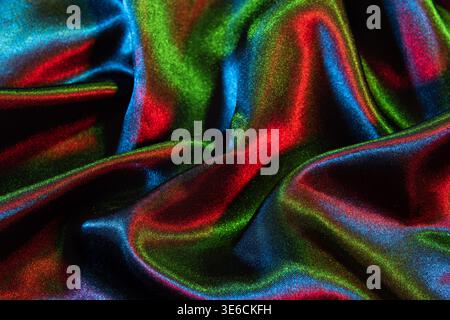 Colorful satin fabric displaying iridescent light and rippling texture Stock Photo