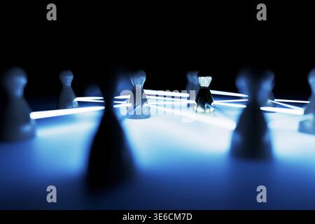 Human Resources and digital network. Glowing blue light beams connect wooden pawn figures, with one central golden leader standing out in sharp focus Stock Photo