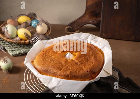 A golden brown Pao de Lo sponge cake sits on a cooling rack in parchment paper. Soft natural lighting highlights the airy texture alongside a rustic b Stock Photo