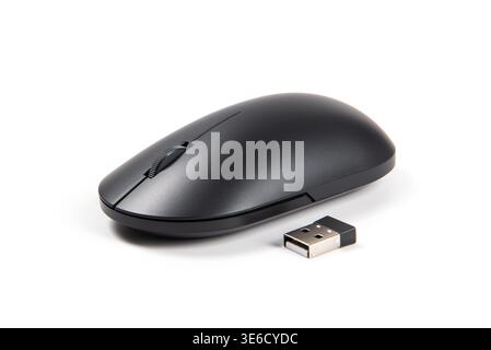 Black wireless optical mouse lying next to its usb receiver on a white background Stock Photo