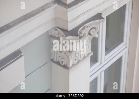 Close-up view showcasing a decorative white column capital with intricate acanthus leaf carvings, highlighting classical architectural style and histo Stock Photo
