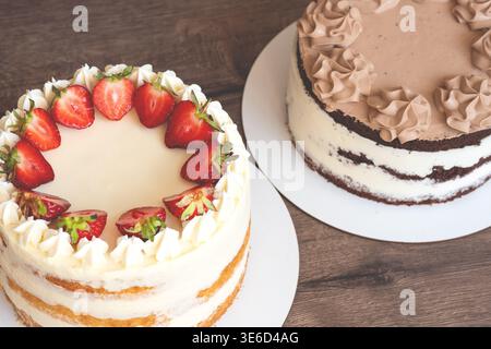 Vertical shot of two different luxury cakes. One is a rich chocolate sponge cake with creamy frosting, and the other is a smooth yellow fruit mousse c Stock Photo