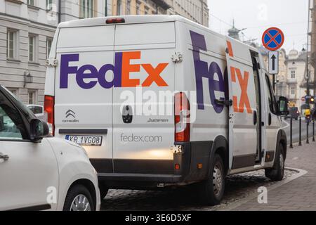 Krakow, Poland - December 2, 2025: Rear view of a white FedEx delivery van with open doors, parked on a city street, crucial for modern parcel shippin Stock Photo