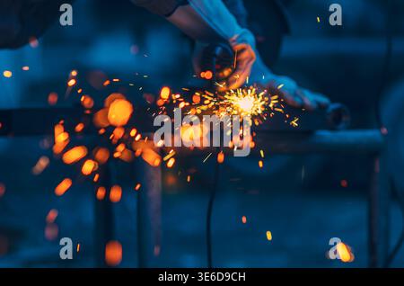 Abstract background with bright flying sparks and glowing particles on dark blue industrial backdrop. Technology and creative design concepts. Stock Photo
