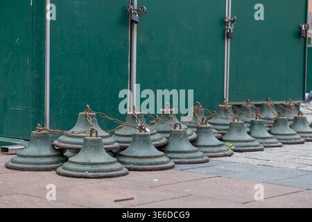 A low-angle perspective shows weathered green chain barriers protecting an urban area, signifying security, closure, and temporary demarcation in a pu Stock Photo