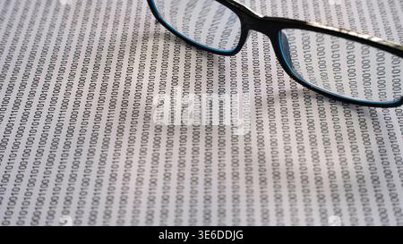 Glasses on binary code background representing data privacy and cybersecurity analysis. Stock Photo
