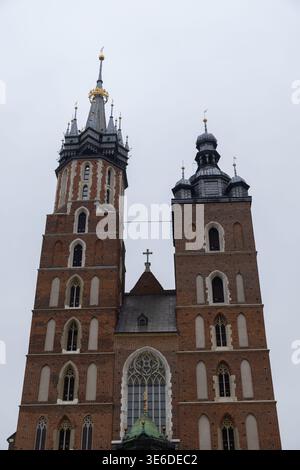 Krakow, Poland - December 1, 2025: St. Mary's Basilica, imposing Gothic brick facade and distinctive twin spires define this renowned European religio Stock Photo