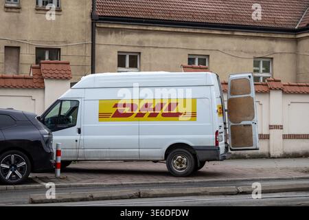 Krakow, Poland - December 1, 2025: DHL white delivery van, open rear door, parked on city street, emphasizing reliable global shipping and efficient e Stock Photo