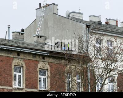 Krakow, Poland - December 1, 2025: Professional roofers working on an old urban building, performing essential repairs and maintenance for property re Stock Photo