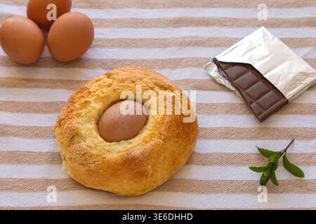 Mona de pascua, a traditional spanish easter cake, with ingredients on a striped fabric Stock Photo