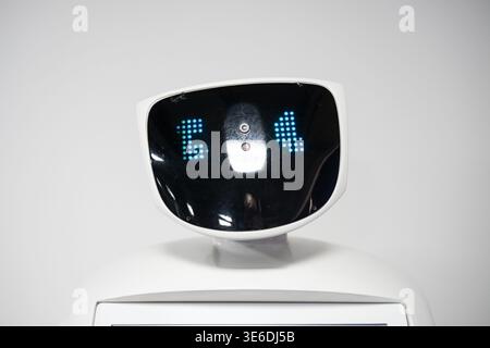 Vladikavkaz, Russia - April 06 , 2026 :  Close-up of Promobot V.4 service robot head with blue pixelated digital eyes on a black screen. Stock Photo