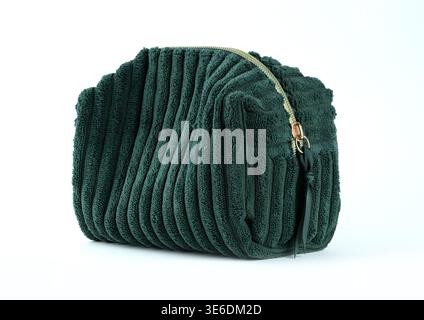 A textured dark green corduroy makeup pouch with gold zipper hardware isolated on white background Stock Photo