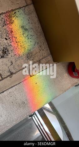 Rainbow light reflection on stone surface inside historic building creating colorful spectrum pattern. Light, color and texture concept. Stock Photo