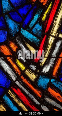 Close up of colorful stained glass pattern with blue red yellow and white elements in Malbork Castle Poland. Light, color and abstract design concept. Stock Photo