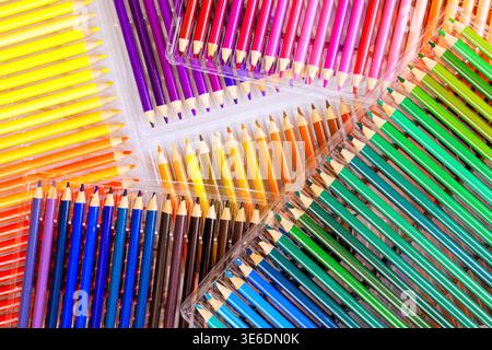 Different boxes hold many colored pencils on clean surface in creative area. Stock Photo
