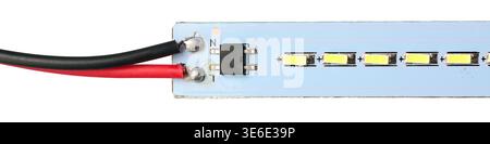 closeup of blue led strip circuit board with soldered red and black wires isolated white background, yellow led components and black electronic chip Stock Photo