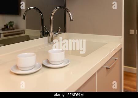 Kitchen Surface with Two White Cups on Saucers Stock Photo