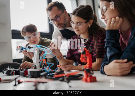 High school students working on robotics project with their teacher. Stock Photo