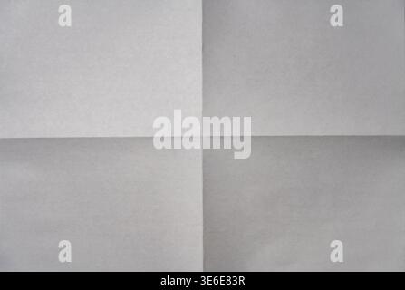 Minimalist background of a white paper sheet folded into four quarters with sharp crease lines in the center. Top view of empty aged document texture Stock Photo
