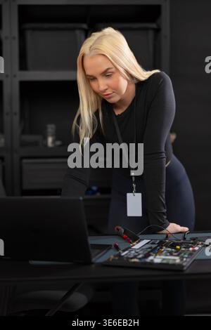 Female IT technician with laptop and hardware setup performing diagnostics and repair Stock Photo