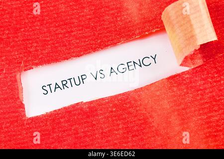 Words Startup VS Agency are shown on a white background. Stock Photo