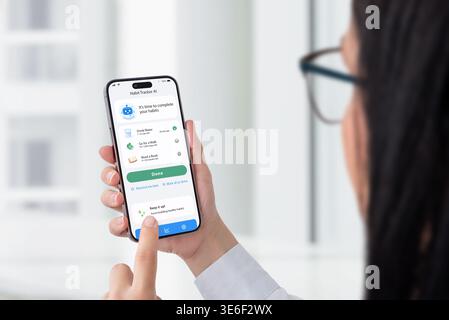 User interacting with habit tracker app on smartphone, productivity and self improvement concept with daily routine tracking in modern workspace Stock Photo