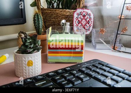 Sticky notes organized in clear holder on desk Stock Photo