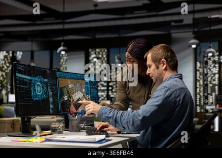 Diverse team of engineers using artificial intelligence to design a floor plan, working together with neural networks and computer aided apartment layout on architectural software. Stock Photo