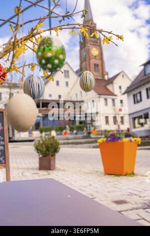Easter eggs hang in front of a church in an urban spring setting, Nagold, Calw district, Germany Stock Photo