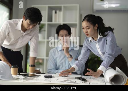 The team focuses on fine-tuning their design concepts during a collaborative review session, highlighting creativity and problem-solving Stock Photo