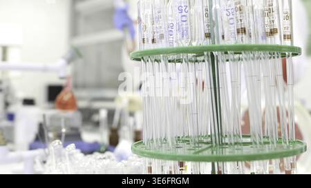 Two female scientist working in laboratory with flasks wearing blue gloves. Two young female scientists working in chemical laboratory. two female res Stock Photo