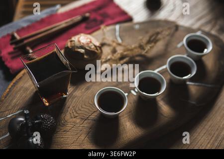 A warm and inviting tea setup displaying beautiful artisan cups and a charming teapot on a rustic wooden tray Stock Photo