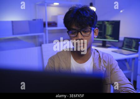 Male Software Engineer Writing Code on Desktop Computer with Multiple Screens Setup. Data center programmer managing large datasets used in AI trainin Stock Photo