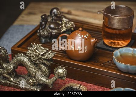 A luxurious tea setup with a vibrant teapot, elegant cups, and a stunning dragon sculpture showcasing artistry Stock Photo
