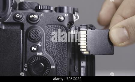 RUSSIA, MOSCOW-DECEMBER, 2020: Memory card in camera. Action. Close-up photographer inserts new memory card into camera. Replacing memory card in came Stock Photo