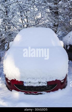 A car completely covered with thick snow after a snowstorm Stock Photo
