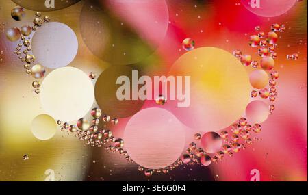 Abstract oil droplets in water reflecting the colors of a background to give a planet effect Stock Photo